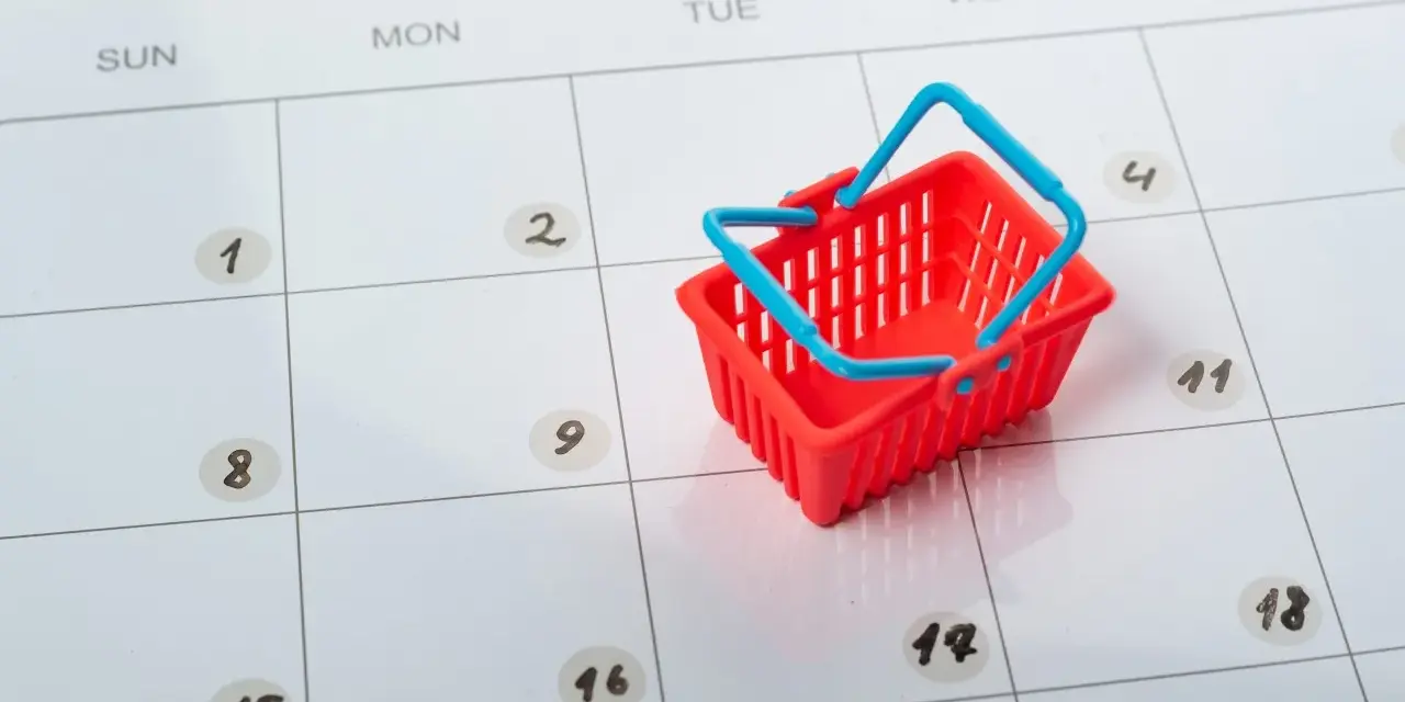Czerwony koszyk na zakupy na kalendarzu. Ile dni z rzędu można pracować, by mieć czas na zakupy?