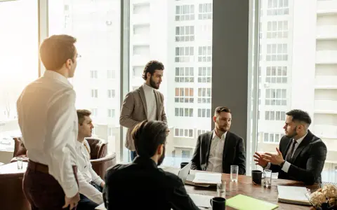 Mężczyźni na spotkaniu biznesowym dyskutują. Jeden z nich gestykuluje, wyjaśniając coś. CTO, co to znaczy?