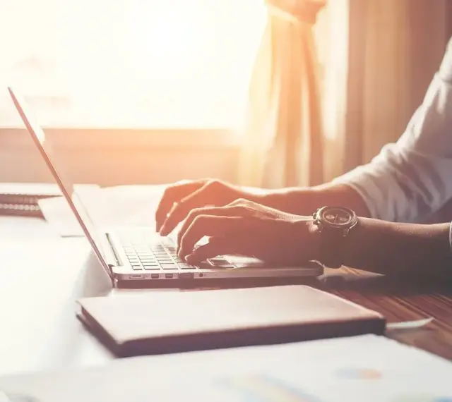 Mężczyzna w białej koszuli pisze na laptopie, zastanawiając się, po jakim czasie dzwonią w sprawie pracy.